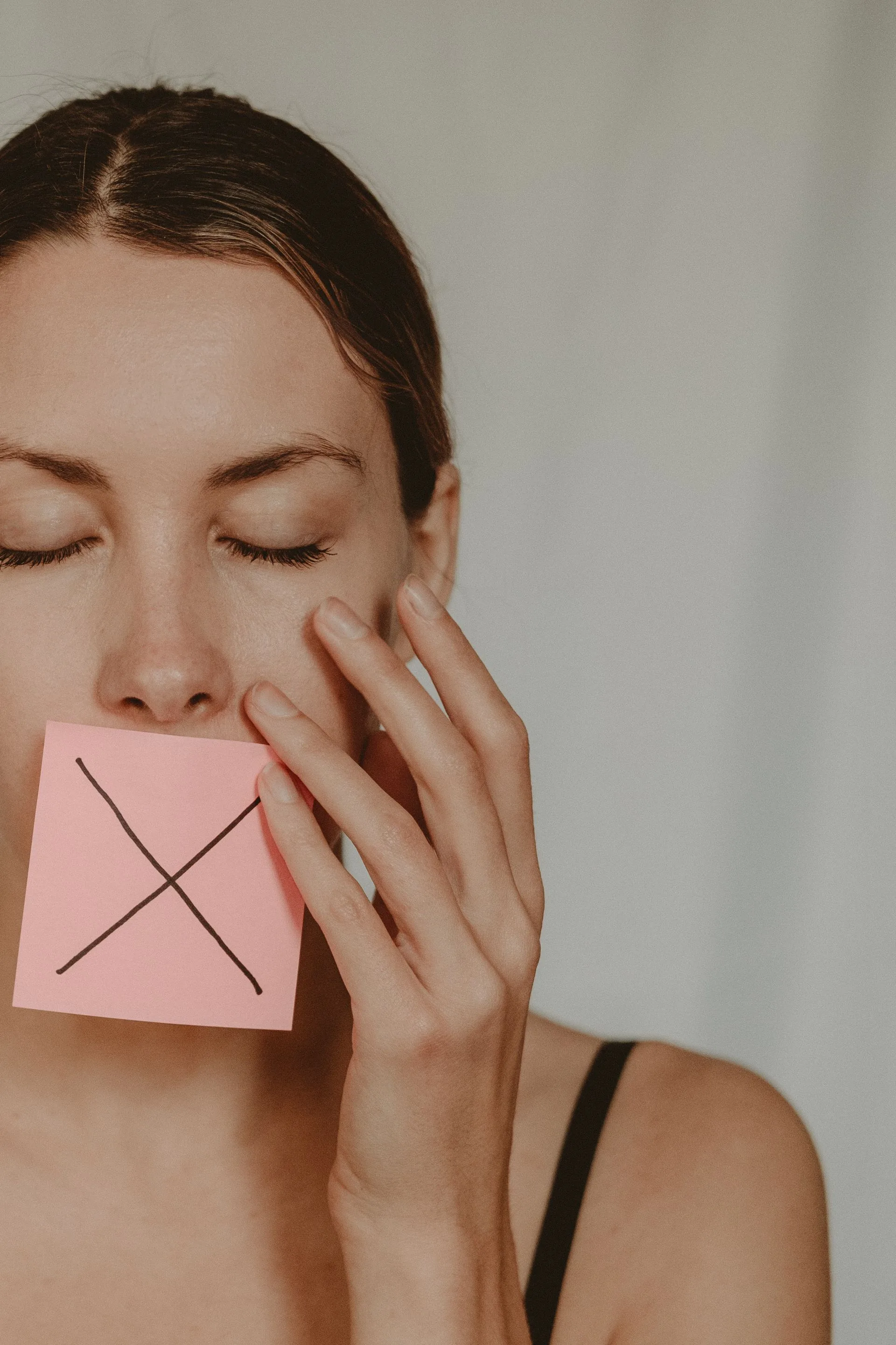 A note with a cross on it held over her mouth, the sentence she stopped saying to herself.