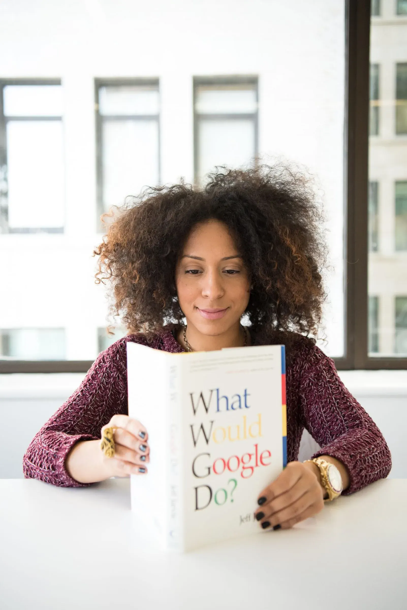A woman reading a book about technology, asking it to explain itself.