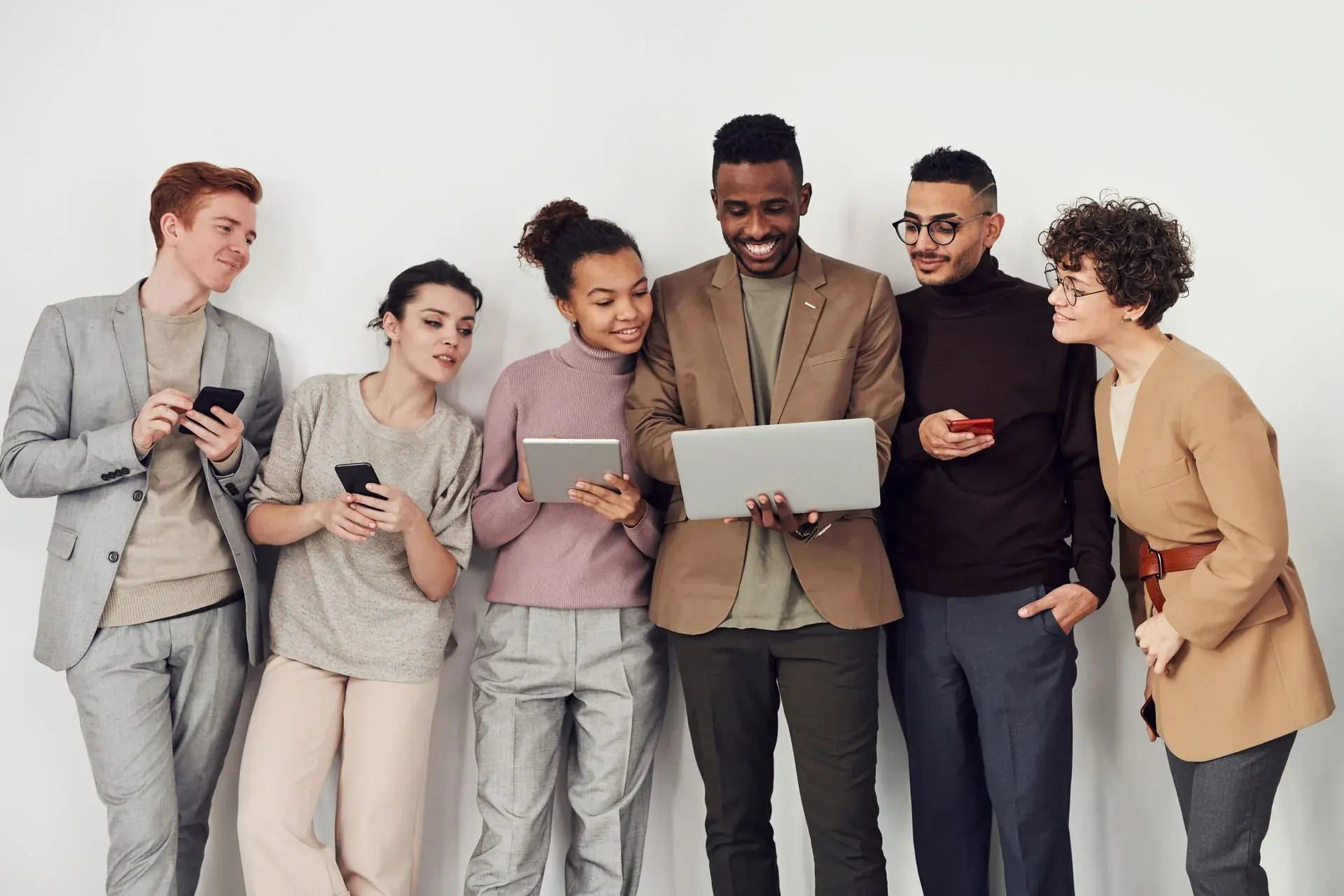 Six people holding their screens and still turned towards each other.