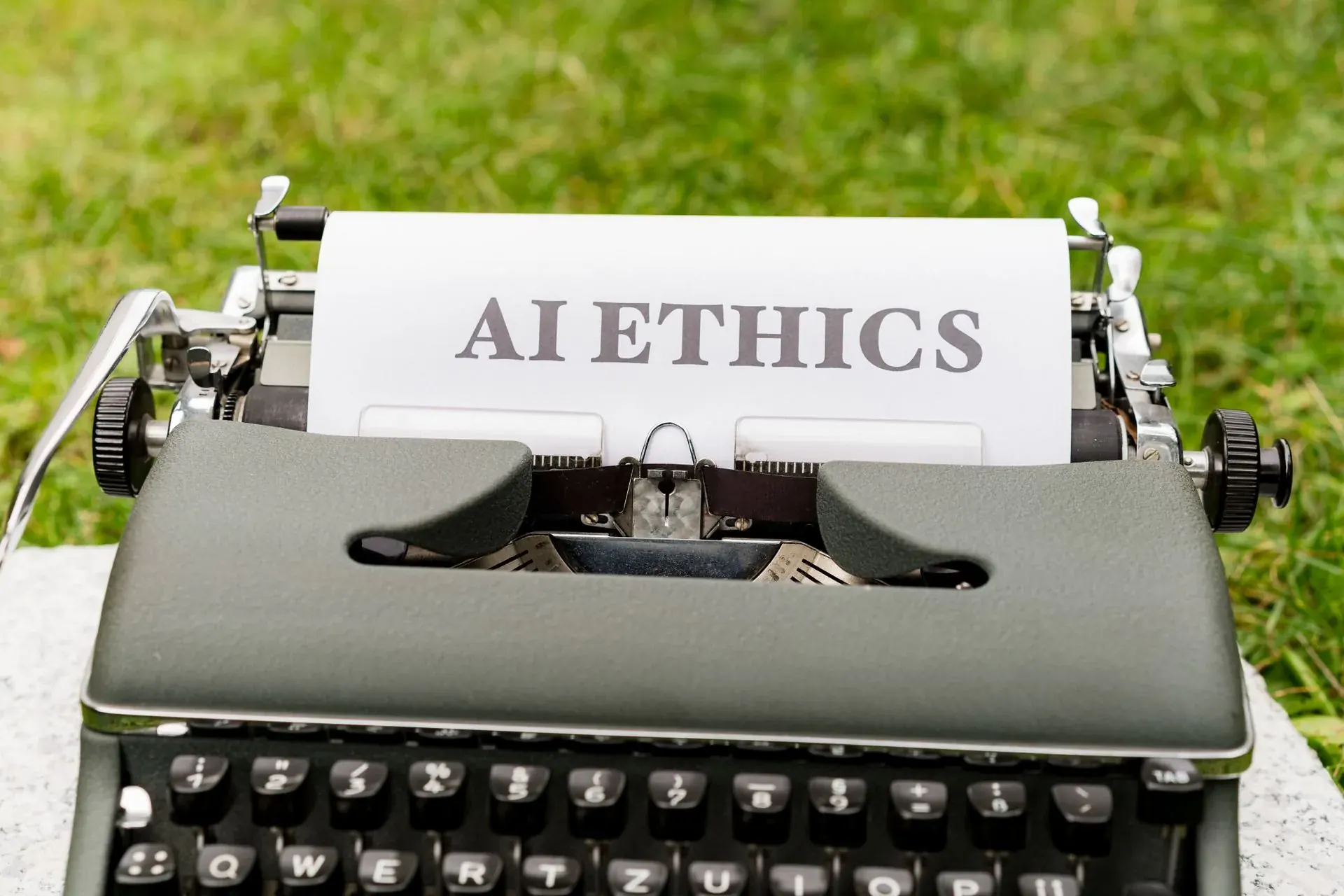 The words AI ETHICS typed on an old typewriter, a large question asked plainly.