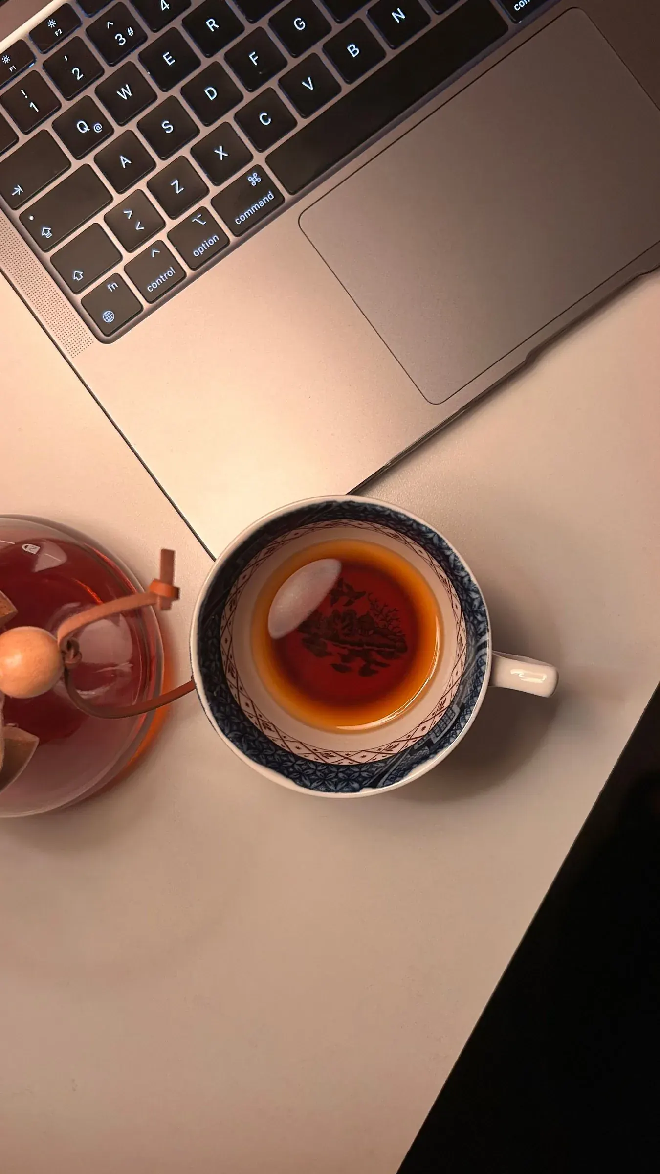 A cup of tea beside the laptop, the time a tool is supposed to give back.