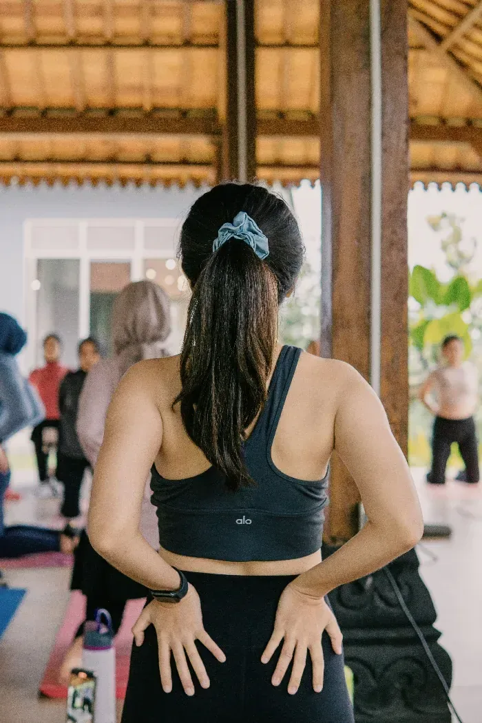 A woman standing among others in a shared room, wellbeing with company in it.