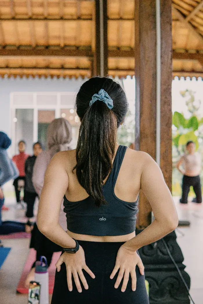 A woman standing among others in a shared room, wellbeing with company in it.