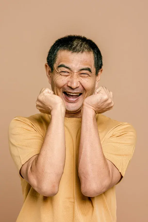 A man caught mid-laugh, the sound that binds a room to itself.